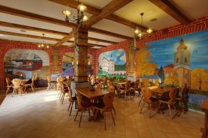 a restaurant with tables and chairs and a mural at Hradní Bašta in Bečov nad Teplou