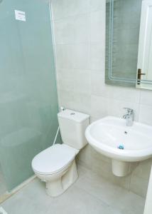 a white bathroom with a toilet and a sink at مجمع الحدائق in Amman