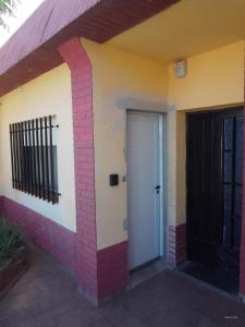 una casa con una porta bianca e un cancello nero di SN - Departamento 2 ambientes Sin cocina - Serena Alojamientos a San Nicolás de los Arroyos
