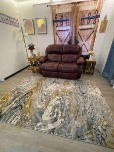 uma sala de estar com uma cadeira reclinável em couro castanho num tapete em Second floor apartment em Mountain Iron