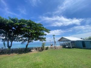 a house with a gazebo next to the ocean at Cobblestone Surf House in Huu