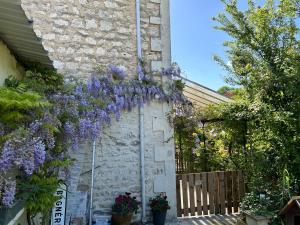 a house with purple flowers hanging from the side of it at PARENTHÈSE Chambre Cosy proche Centre et Gare in Angoulême