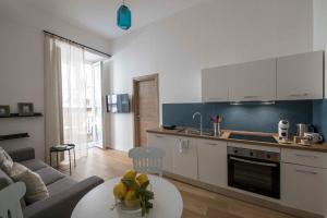 una cucina e un soggiorno con un divano e un tavolo di La casa di Nelly Boutique Apartment Napoli a Napoli