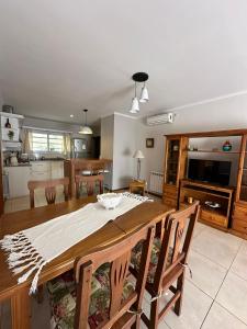 cocina y comedor con mesa de madera y sillas en Casa Aurora en Olavarría