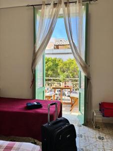 a room with a bed and a door with a window at La Casetta di Romeo in Trapani +7 photos