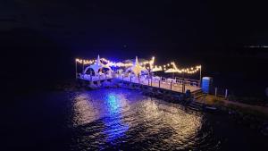 een pier met 's nachts licht op het water bij Hotel La Fragata in Coveñas