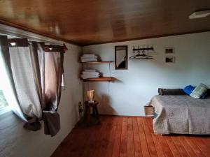 1 dormitorio con 1 cama y suelo de madera en Departamento para cinco, full equipado, en Colonia del Sacramento