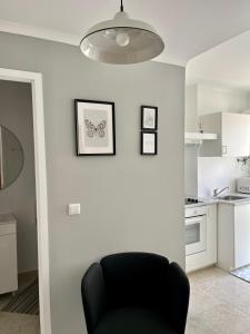 un salon avec une chaise noire et une cuisine dans l'établissement Mouraria - Apartamento, à Lisbonne