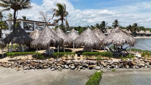 un grupo de sombrillas de paja en una playa en Hotel La Fragata, en Coveñas