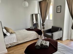 - une chambre avec deux lits, une chaise et un miroir dans l'établissement Mouraria - Apartamento, à Lisbonne
