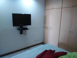 1 dormitorio con 1 cama y TV de pantalla plana en Acogedor apartamento con piscina - Bleu Marine Suites, en La Guaira