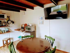 cocina con mesa y TV en la pared en Departamento para cinco, full equipado, en Colonia del Sacramento
