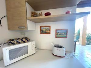 a kitchen with a microwave and a blender at Casa I Corbezzoli - Paduledda - Isola Rossa in Cascabraga