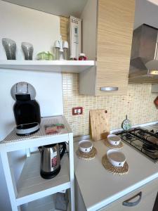 a kitchen with a counter with a coffee maker on it at Casa I Corbezzoli - Paduledda - Isola Rossa in Cascabraga