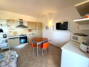 a kitchen with a table and chairs in a kitchen at Casa I Corbezzoli - Paduledda - Isola Rossa in Cascabraga +39 photos
