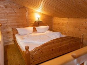 um quarto com uma cama num chalé de madeira em Urige Doppelhaushälften 3 und 4 em Grafenweg