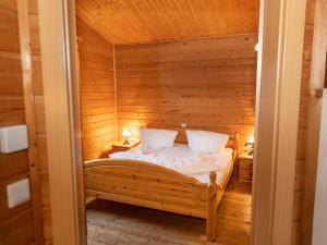 ein Schlafzimmer mit einem Bett in einem Holzzimmer in der Unterkunft Uriges Chalet 1 in Grafenweg
