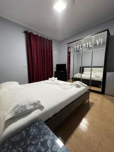 una camera con un grande letto e uno specchio di Hotel Silvio a Fier
