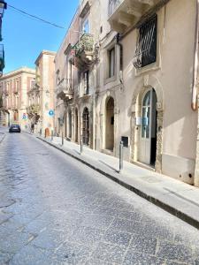 an empty street in a city with buildings at Ortigia Dreaming in Siracusa