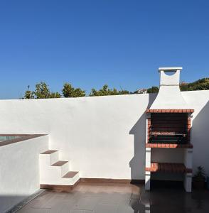 a white wall with a staircase next to a building at Pátio 7 & Meio DiscoverAlentejo in Moura