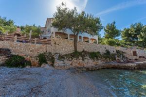 a house on a stone wall next to the water at Apartment Zastupac 8761c in Hvar