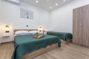een hotelkamer met twee bedden met groene lakens bij Apartment Zastupac 8761c in Hvar