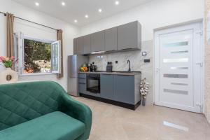 een woonkamer met een groene bank en een keuken bij Apartment Zastupac 8761c in Hvar