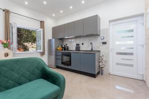 a living room with a green couch and a kitchen at Apartment Zastupac 8761c in Hvar