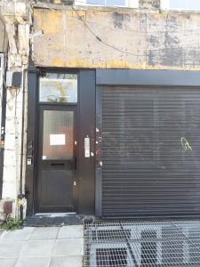 uma porta preta de um edifício com uma garagem em Evergreen Apartments, Flat 3, London em Londres