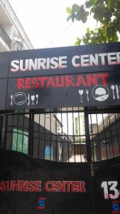 un panneau devant un bâtiment avec un panneau central au lever du soleil dans l'établissement Sunrise Center Bonapriso 111, à Douala