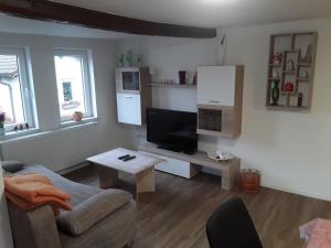 ゲルスフェルトにあるFerienwohnung 85 , Gersfeld Rhön , Ortsmitte , frisch saniert , Gästehaus Mierdelのソファとテレビのあるリビングルーム