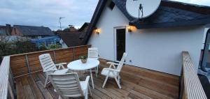 ゲルスフェルトにあるFerienwohnung 85 , Gersfeld Rhön , Ortsmitte , frisch saniert , Gästehaus Mierdelのデッキにテーブルと椅子が置かれたパティオ