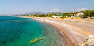 uma vista para uma praia com o oceano em Corafili Holiday Suites em Kiotari