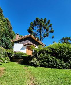 a house on a hill with a tree in the background at Chalés Monte Verde in Monte Verde