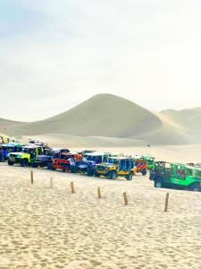 eine Reihe von Autos, die in der Wüste geparkt sind in der Unterkunft HOSPEDAJE WELCOME paracas in Paracas