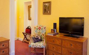 a living room filled with furniture and a tv at The Royal Highland Hotel in Inverness