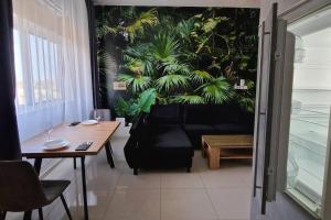 sala de estar con mesa y pared de plantas en Jungle Sensation, en Lomé