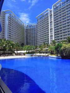 un gran hotel con una gran piscina azul frente a él en Staycation at Azure by Mariane, en Manila