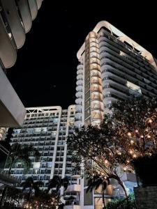un edificio de apartamentos alto y blanco por la noche en Staycation at Azure by Mariane, en Manila