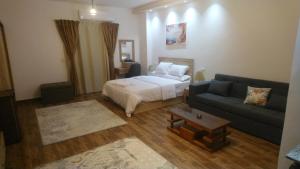 una habitación de hotel con una cama y un sofá en Apartments Next to Mivida, en New cairo 19 fotos más