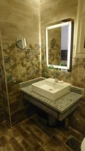a bathroom with a sink and a mirror at Apartments Next to Mivida in New cairo +19 photos