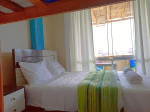 HOSPEDAJE WELCOME paracas في باراكاس: غرفة نوم بسرير ابيض ونافذة