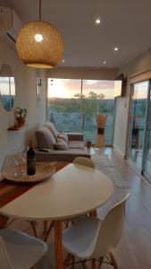 uma sala de estar com um sofá, uma mesa e cadeiras em Son Del Viento em La Cumbre