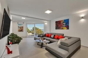 un soggiorno con un divano e un tavolo di Family friendly apartments with a swimming pool Podgora, Makarska - 11937 a Podgora