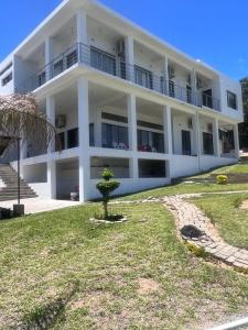 a large white building with a tree in front of it at Luxury 2-story retreat with private pool in Bilene beach in Macia