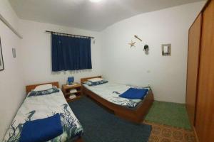 a bedroom with two beds and a window at Apartments by the sea Murter - 22397 in Murter