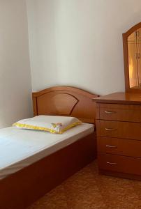 a small bedroom with a bed and a dresser at Stiven’s Apartment in Berat