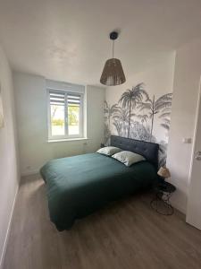 een slaapkamer met een groen bed en een raam bij Le cyprès avec jacuzzi seh'loué in Ploufragan