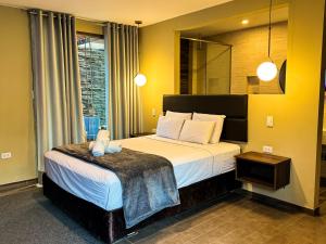 1 dormitorio con 1 cama grande y espejo en Hotel Campo & Leña, en Cieneguilla