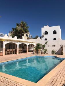 una piscina frente a un edificio blanco en Riad Dar Sarah, en Taghazout